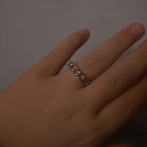 Silverfärgad kedjering - Säljer en snygg silverfärgad ring med kedjemönster runt hela bandet. Ringen har en cool och modern design som sticker ut och passar perfekt för dig som gillar detaljer. Materialet är metall med blank finish och den är bekväm att bära.