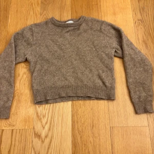 Beige stickad tröja från Zara - Mysig beige brun stickad tröja från Zara med rund halsringning och ribbade muddar. Lite kortare men  är perfekt för lager-på-lager under kyliga dagar. Långärmad och i mjukt material som känns skönt mot huden.