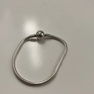 Pandora silverarmband med lås - Snyggt silverarmband från Pandora med klassiskt rullås där Pandora-loggan är ingraverad.