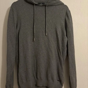 Grå kashmir hoodie - Snygg grå hoodie från Ragman med mjukt stickat material och ribbade muddar. Tröjan har huva med snörning och långärmad passform, perfekt för chill dagar. Metallmärke med Ragman-logga framtill ger en clean detalj.använd få tal gånger 