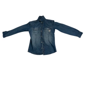 Blå jeansskjorta med knappar - Snygg blå jeansskjorta med klassisk krage och långa ärmar. Skjortan har två bröstfickor med knappstängning och detaljerade sömmar. Perfekt för dig som gillar en avslappnad och cool stil. Knappar längs hela framsidan för enkel på- och avtagning.