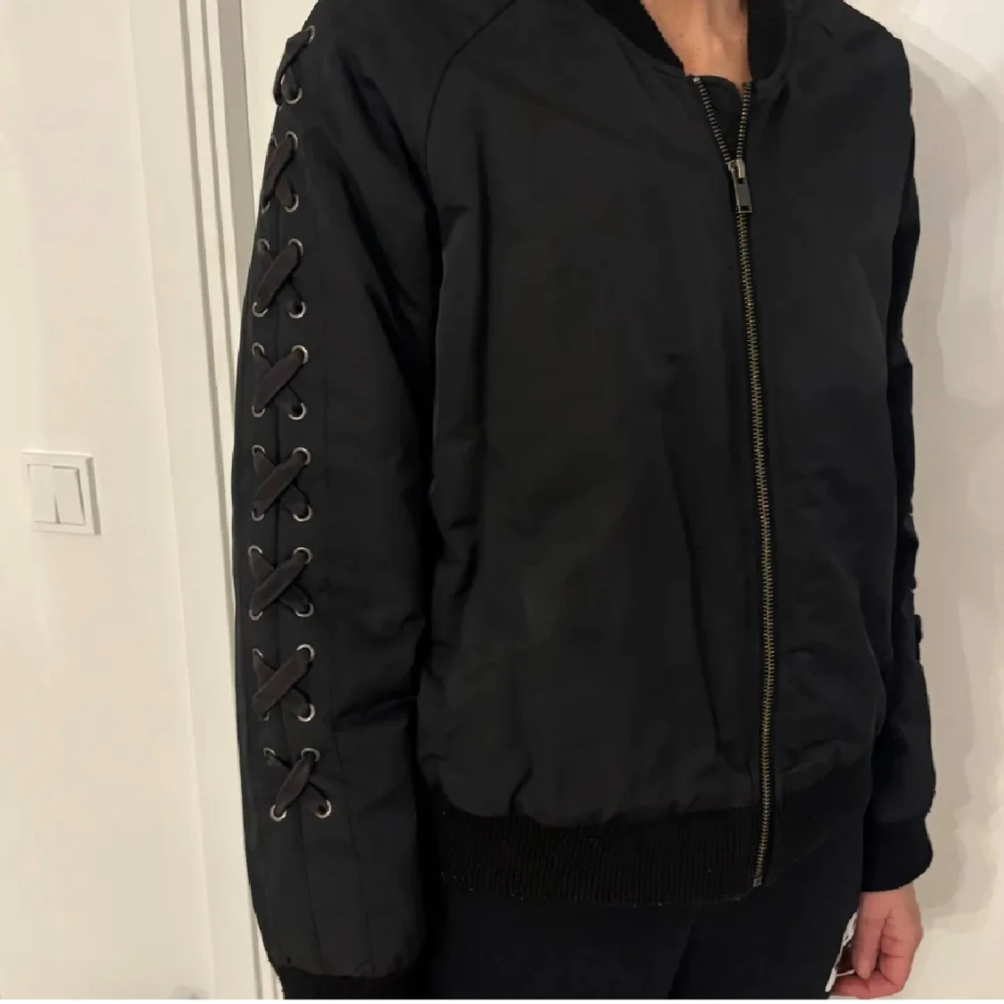 Svart bomberjacka med snörning