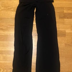 Yoga pants från Bikbok  - Säljer ett par svarta byxor med hög midja och wide fit. De har en enkel och clean look, perfekta för dig som gillar stilrena och bekväma plagg. Materialet känns mjukt och följsamt, vilket gör dem sköna att bära hela dagen.