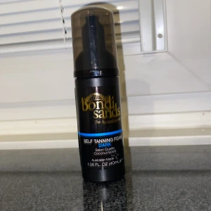 Bondi Sands Self Tanning Foam Dark - Bondi Sands Self Tanning Foam i färgen Dark med kokosdoft. Flaskan är svart med guld- och blå detaljer och har en praktisk pump. Innehåller 40 ml och ger en djup solbrun ton. Perfekt för dig som vill ha en intensiv bränna med salongskänsla.