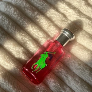 Ralph Lauren rosa parfymflaska - Snygg parfym från Ralph Lauren med en röd flaska och ikonisk grön logga. Ca halva kvar (25ml, utav 50ml). Fastpris 75kr, rabatt vid fler köp 💕