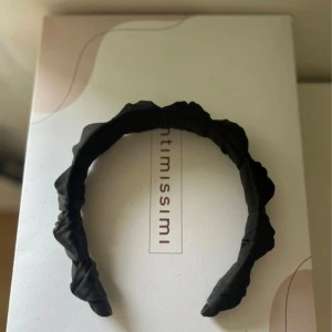 Svart diadem med twistad design - Snyggt svart diadem med twistad och lätt rynkad design. Diademet är klätt i ett mjukt tyg som ger en cool och trendig look. Perfekt accessoar för att lyfta vilken outfit som helst.