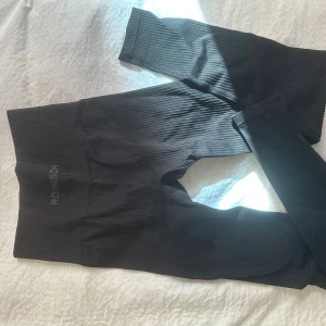 Svarta ribbade träningsbyxor från Röhnisch - Svarta ribbade leggings från Röhnisch med hög midja och tight passform i strlk XS/S.