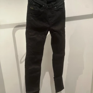 Svarta Tiger of Sweden jeans - Svarta jeans från Tiger i modell skinny. Midwaist i strlk 26/30.