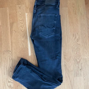 Jack and Jones Jeans - Snygga mörkblå jeans från Soft & Blue i storlek 30/32. Modellen är skinny med klassisk femficksdesign och normal midja. Jeansen har en stilren look med diskreta sömmar och är tillverkade i stretchigt denim för extra komfort.