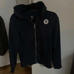Svart hoodie från Converse med dragkedja - Snygg converse zip hoodie. Den är välanvänd fast väldigt sparsamt. Den är köpt direkt från kids brandstore med storleken 150-160