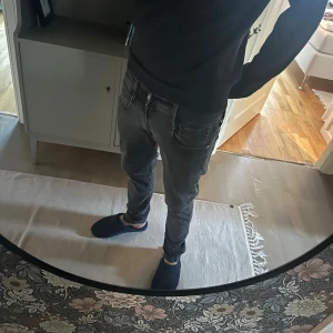 Svarta Replay Anbass jeans, stl 31 - Säljer ett par svarta Replay Anbass jeans i storlek W31 L32. Jeansen har en slim passform med klassisk femficksdesign och snygga detaljer vid fickorna. Materialet är stretchigt och bekvämt, perfekt för dig som gillar en modern och stilren look. Riktigt bra skick, som nya! Kom gärna med prisförslag! Kontakta gärna vid fler frågor.