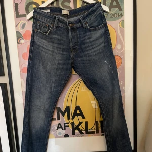 Jack & Jones jeans - Snygga blå jeans från Jack & Jones, modell Slim Glenn. Jeansen har en slim passform, klassisk femficksdesign och slitningar framtill för en cool look. Tillverkade i bomull med tydliga kontrastsömmar och läderpatch bak i midjan. Kol privat för fler frågor och funderingar:) mvh