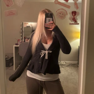 Svart kofta med knyt från Odd Molly - Supersöt svart kofta från Odd Molly med volangkant och grått knytband framtill. Skulle säga att den är XS men passar även storlek S, skriv för fler frågor eller bilder💗☺️