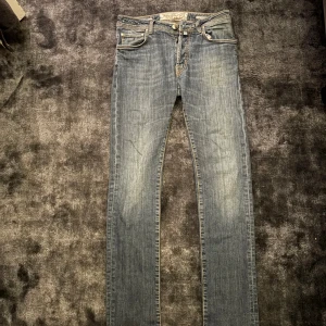 Jacob Cohen 688 Comfort jeans blå - Snygga blå jeans från Jacob Cohen, modell 688 Comfort. Jeansen har klassisk femficksdesign, kontrastsömmar och en blå patch med logga bak. Materialet är mjukt denim med lätt tvättad look och raka ben. Perfekta för dig som gillar stilrena och bekväma jeans.
