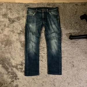 Nudie Lean Dean  - Snygga blå jeans från Nudie med riktigt fet tvätt och lite slitningar. Modellen är Lean och storlek 32/32 men är uppsydda till 32/30 ungefär. Finns även lite lagningar i fickorna. (Jeansen är inte lika mörka som på bilderna)