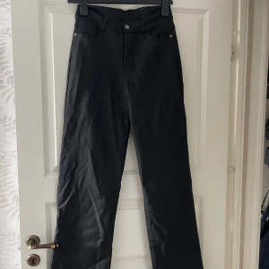 Svarta vida byxor, Jeans  - Snygga svarta byxor med raka, vida ben och klassisk femficksdesign. Byxorna har hög midja, jeans som känns skönt mot huden. Perfekta för dig som gillar en stilren och avslappnad look.