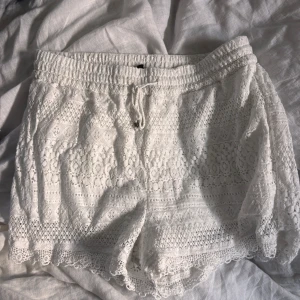 Vita spets shorts  - Säljer ett par snygga vita spetsshorts från vero Moda. 