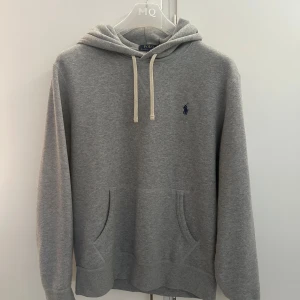 Grå hoodie från Polo Ralph Lauren - Grå hoodie från Polo Ralph Lauren i storlek M. Endast använd ett fåtal gånger och i mycket fint skick.