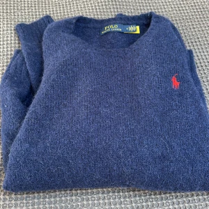 POLO RALPH LAUREN Alpaca Crew Neck Sweater Bright Navy - Stickad tröja från Polo Ralph Lauren, tillverkad i alpacka. Nyskick, endast använd ett fåtal gånger. Passar ej längre. Storlek M. Nypris 3000 kr. Obs! Ej hårig utan det är materialet. 