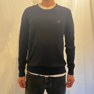 kashmirtröja från Peak Performance - Säljer en stilren mörkblå tröja från Peak Performance i kashmirblandning. Klassisk rund halsringning, liten broderad logga på bröstet och ribbade muddar. Perfekt för dig som gillar en clean och tidlös look. Storlek L men passa M. Modellen är 180cm.