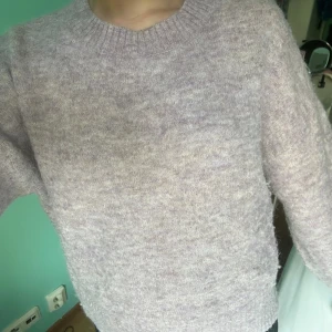 Ljuslila stickad tröja från C - Mysig ljuslila stickad tröja från Cubus i storlek S. Tröjan har rund halsringning, ribbade muddar och lång ärm. Perfekt för att hålla sig varm under kyliga dagar och har en loose passform som ger en chill vibe.