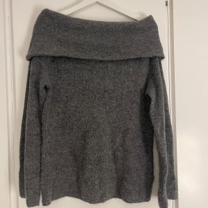 Grå offshoulder stickad tröja H&M - Säljer en snygg grå offsholder stickad tröja från H&M i storlek XS. Perfekt för att ge en chill och trendig vibe. Materialet är mjukt och ribbat, vilket gör den extra skön att bära.