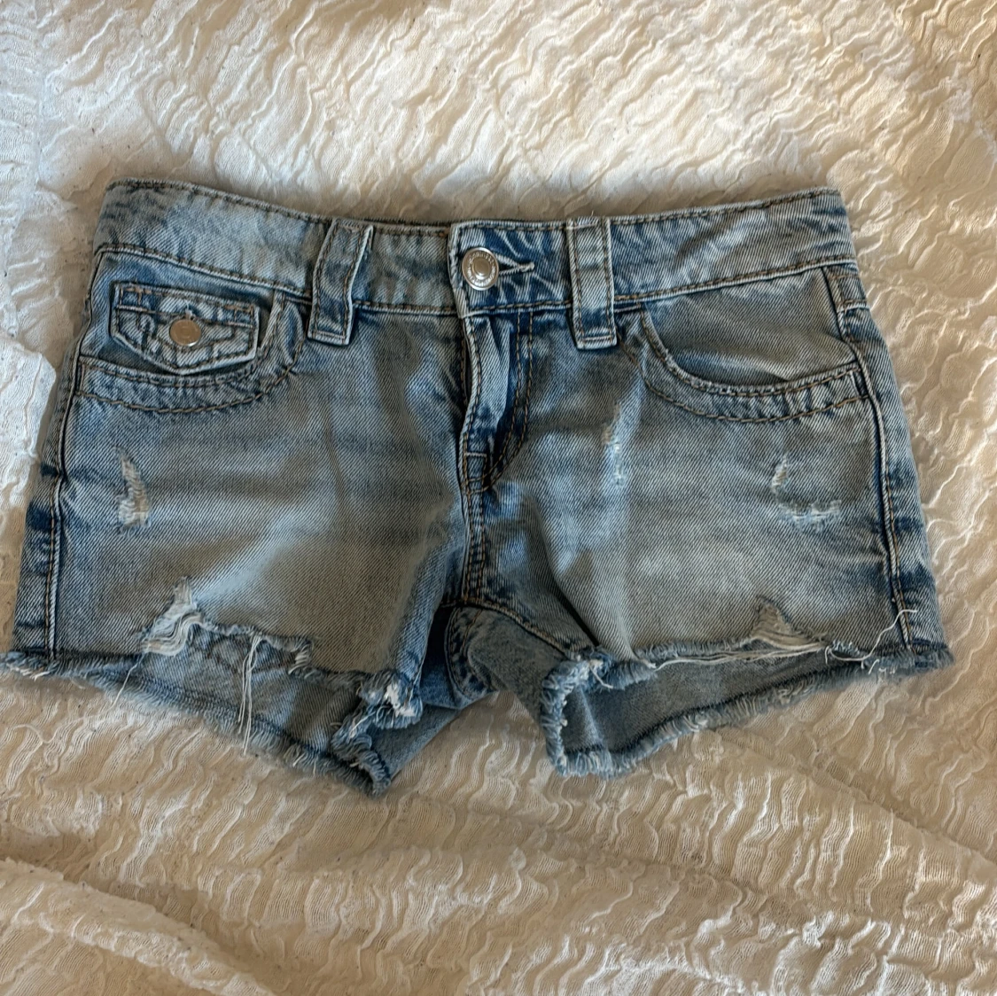 Blå jeansshorts med broderade fickor