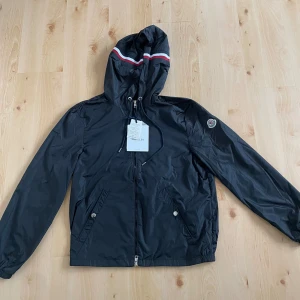 Moncler vindjacka  - Svart ny moncler vindjacka lite skrynklig med det går bort med strykjärn eller steam. Perfekt nu för hösten och våren när det börjar bli lite kyligt. Nfc finns skriv privat för att se bild.