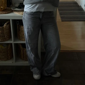Gråa wide jeans med rak passform - Säljer ett par gråa jeans med breda ben och rak passform. Jeansen har klassisk femficksdesign, normal midja och är tillverkade i denim. Perfekta för dig som gillar en avslappnad och trendig look.