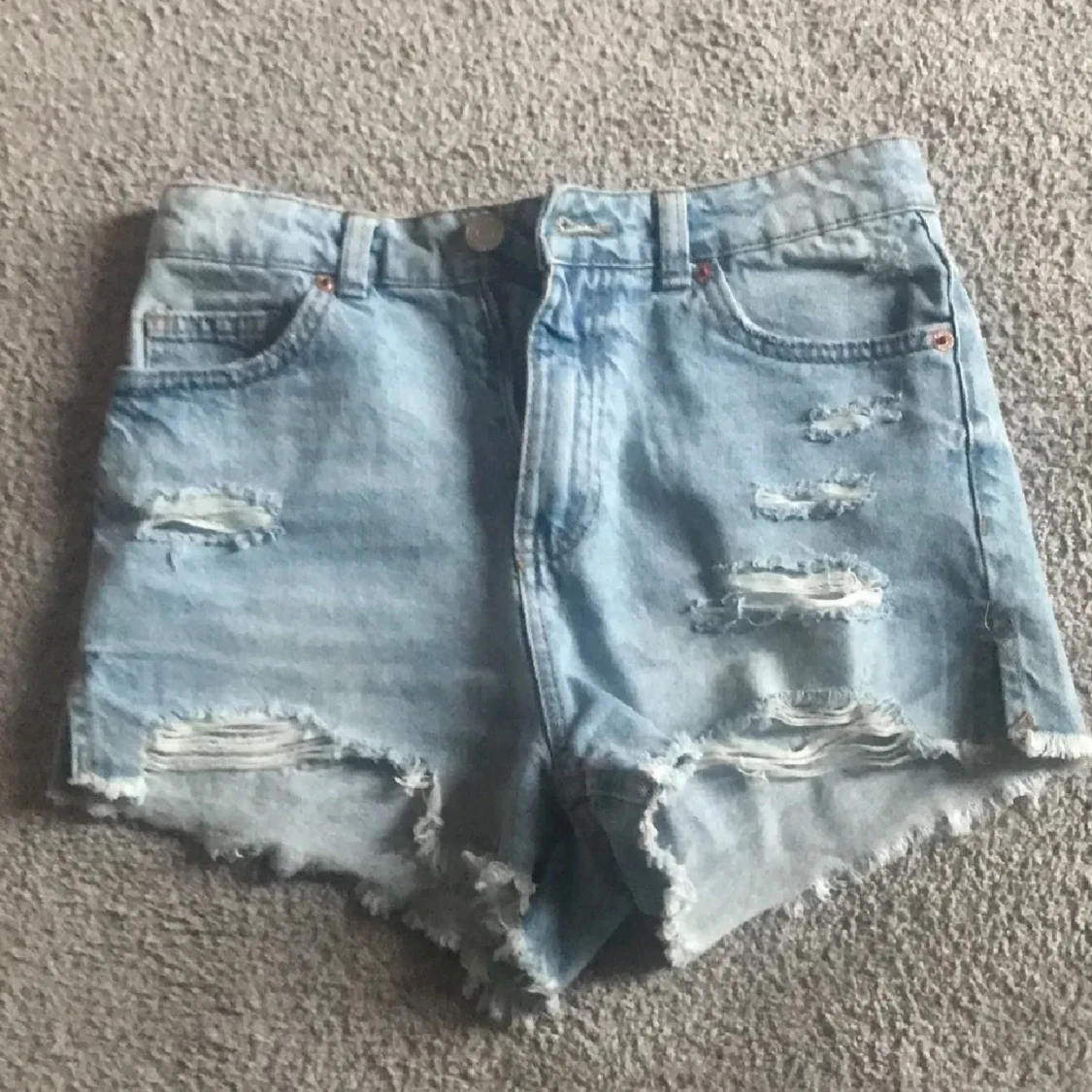 Ljusblå slitna jeansshorts