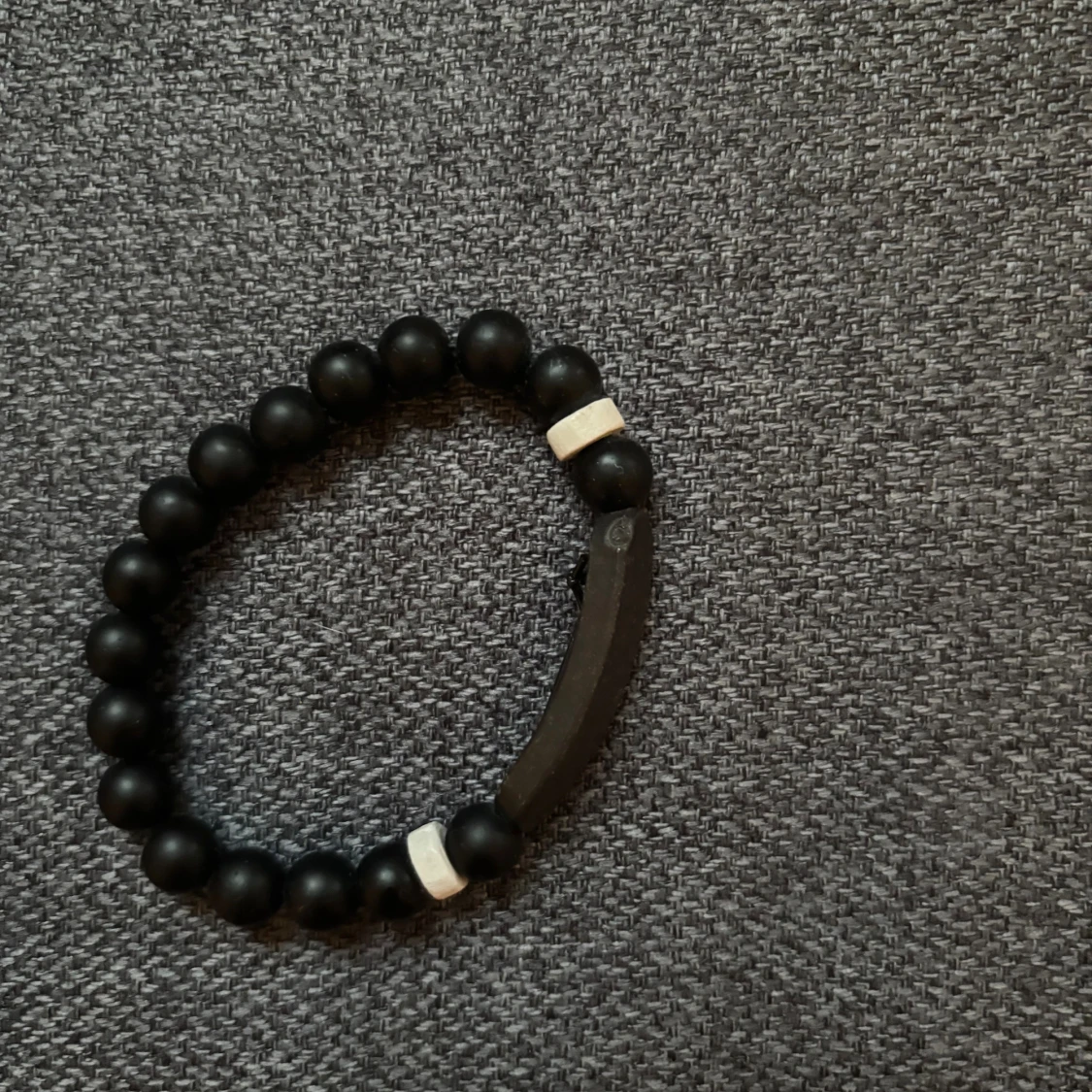 Svart pärlarmband med vita detaljer