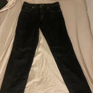 Svarta jeans från Armani Jeans - Svarta jeans från Armani Jeans med klassisk femficksdesign och silverfärgad logga på bakfickan. Jeansen har raka ben, normal passform