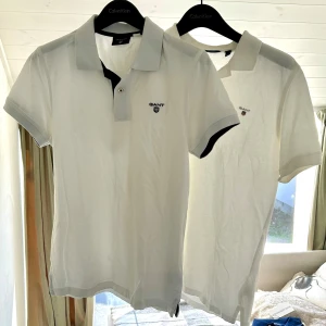 Två vita GANT pikéer - Två vita GANT pikéer strl S, ena med blå krage och den andra helvit som är knappt använda.        Nypris 1 piké ca 500kr.      1st för 170kr 2st för 300