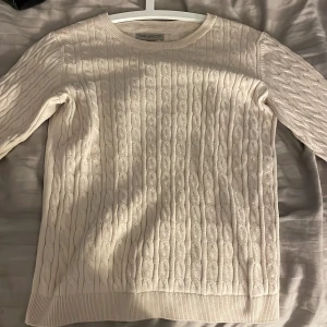 Beige kabelstickad tröja från Basic You - Kabelstickad beige tröja från Basic You med rund halsringning och ribbade muddar. Klassisk och stilren design med lång ärm. Mjuk och skön känsla, passar till jeans eller kjol.💗