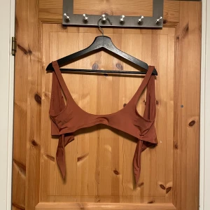 Orange/brun bikinitopp - Säljer en ryggknuten orange/brun bikinitopp från LINDEX i storlek S.