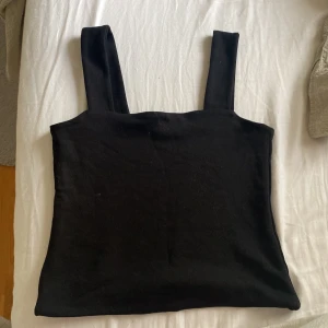 Svart linnetopp från Lindex XS - En stilren svart linnetopp från Lindex med breda axelband och rak passform. Toppen är gjord i mjuk bomull och passar perfekt till jeans eller kjol. Enkel och clean look som funkar till många olika stilar.