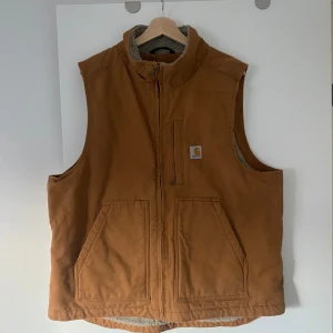 Brun Carhartt väst - Säljer en helt ny brun väst från Carhartt. Väst med två stora fickor framtill och dragkedja. Inga fläckar eller liknande, var för stor för mig.