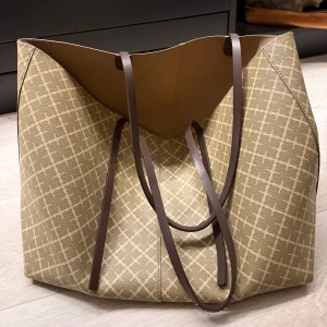 Beige shoppingväska med brunt mönster - Funderar på att sälja min By Malene Birger väska som köptes förra sommaren, fint skick förutom banden som är lite slitna men går att fixa!!🌟🌟💕