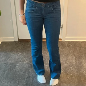 Blå bootcut jeans från ONLY, 29/34 - Snygga blå jeans från ONLY i bootcut-modell med klassisk femficksdesign och normal passform. Jeansen har medelhög midja, dragkedja och knapp framtill samt diskreta sömmar. Perfekta för dig som gillar en tidlös och avslappnad look.