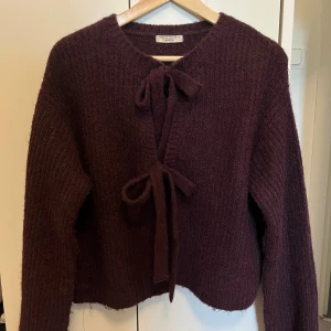 Vinröd tröja - Säljer en supersnygg vinröd stickad tröja/kofta från Gina tricot, då den inte kommer till användning. Använd fåtal gånger så den är i nyskick.