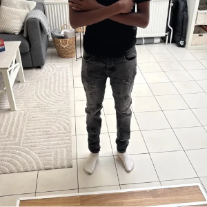 Grå jeans från Cars Jeans - Säljer ett par gråa super skinny jeans från Cars Jeans. Jeansen har en tight passform, klassisk femficksdesign och coola slitningar samt stänkdetaljer för en trendig look. Perfekta för dig som gillar en smal siluett och streetstyle.