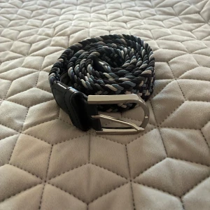 John Henric flätat bälte - Ett flätat bälte i storleken 43/110 cm! Oanvänt.