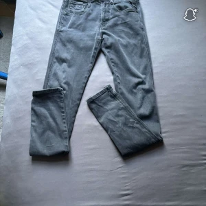 Replay grå jeans, midwaist, W27 L32 - Säljer ett par grå jeans från Replay i modellen midwaist. Jeansen har klassisk femficksdesign, raka ben och snygga detaljer på bakfickorna. Materialet är mjukt jeans och färgen är en mörkgrå ton som passar till allt.