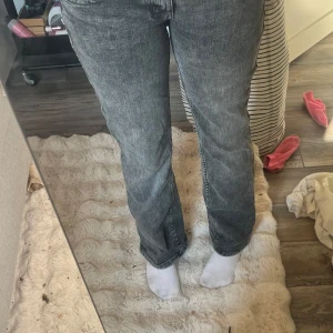 Grå bootcut jeans med tvättad look - Säljer ett par grå jeans med tvättad finish och bootcut-modell. Jeansen har klassiska fem fickor, raka ben med lätt utsvängning och normal passform. Materialet är jeans och färgen är en snygg mörkgrå ton som passar till det mesta. Nästan aldrig använda. Från hm i storlek 38, passar mig som har 27-28w och är 170cm lång 