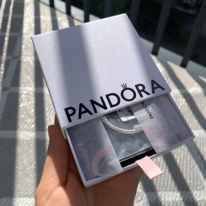 Pandora silverarmband med hjärtformad lås - Snyggt och klassiskt armband från Pandora i äkta silver. Armbandet har en tunn, ormlänkskedja och ett hjärtformat lås med diskret Pandora-logga. Kommer i original ask med silkespapper och etikett. Perfekt för att samla dina favoritberlocker. 17 cm och den är ÄKTA!! O använd och helt ny! PRIS KAN DISKUTERAS VID SNABBA KÖP