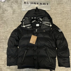 Pufferjacka Burberry blir till väst - En svart pufferjacka från Burberry den är storlek M och så blir den till en också. Perfekt för vintern och sommarn med västen