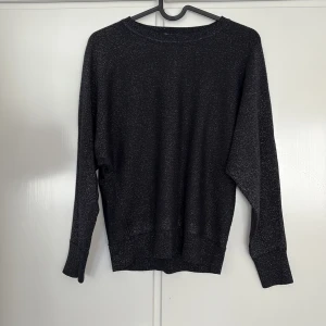 Svart glittrig tröja från Esprit - Säljer en svart glittrig tröja från Esprit i storlek XS. Tröjan har rund halsringning, långa ärmar och en mjuk, lite stretchig känsla. Perfekt för dig som vill ha något enkelt men ändå med lite extra bling.