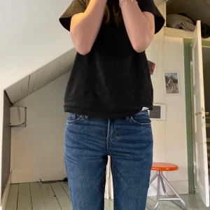Blå bootcut jeans med medelhög midja  - Säljer ett par klassiska blå jeans med bootcut och medelhög midja. Jeansen har fem fickor, bälteshällor och dragkedja fram. Snygg passform som sitter tajt upptill och släpper vid benen. Perfekta till sneakers eller boots. Säljer då de är för korta för mig! Jeansen är från kappahl