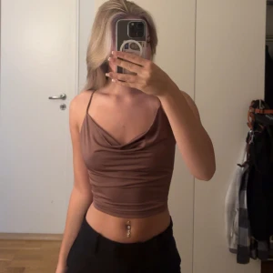 Brun croppad linnetopp med snörning - Säljer ett ursnyggt brunt croppad linnetopp från bikbok i storlek xs. Toppen har öppen rygg med korsad snörning som knyts längst ner. 100kr men öppen för prisförslag🤩