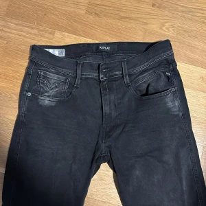 Svarta Replay Anbass jeans slim fit - Säljer ett par svarta Replay Anbass jeans i slim fit. Använda 1-2 ggr, pris kan diskuteras! Storlek W31 L32, Nypris 1800